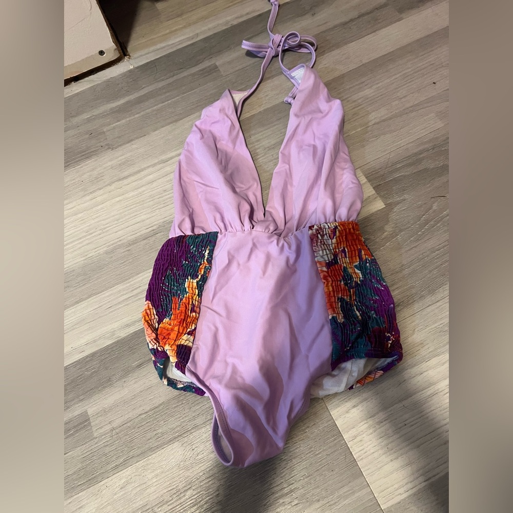 New without tags. 6 SHOREROAD lavender 1 piece with floral ruching. Size Small